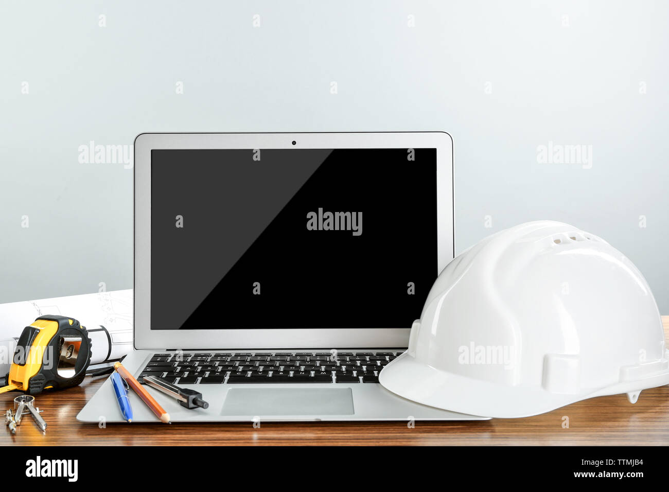 Laptop with construction tools on wooden table Stock Photo