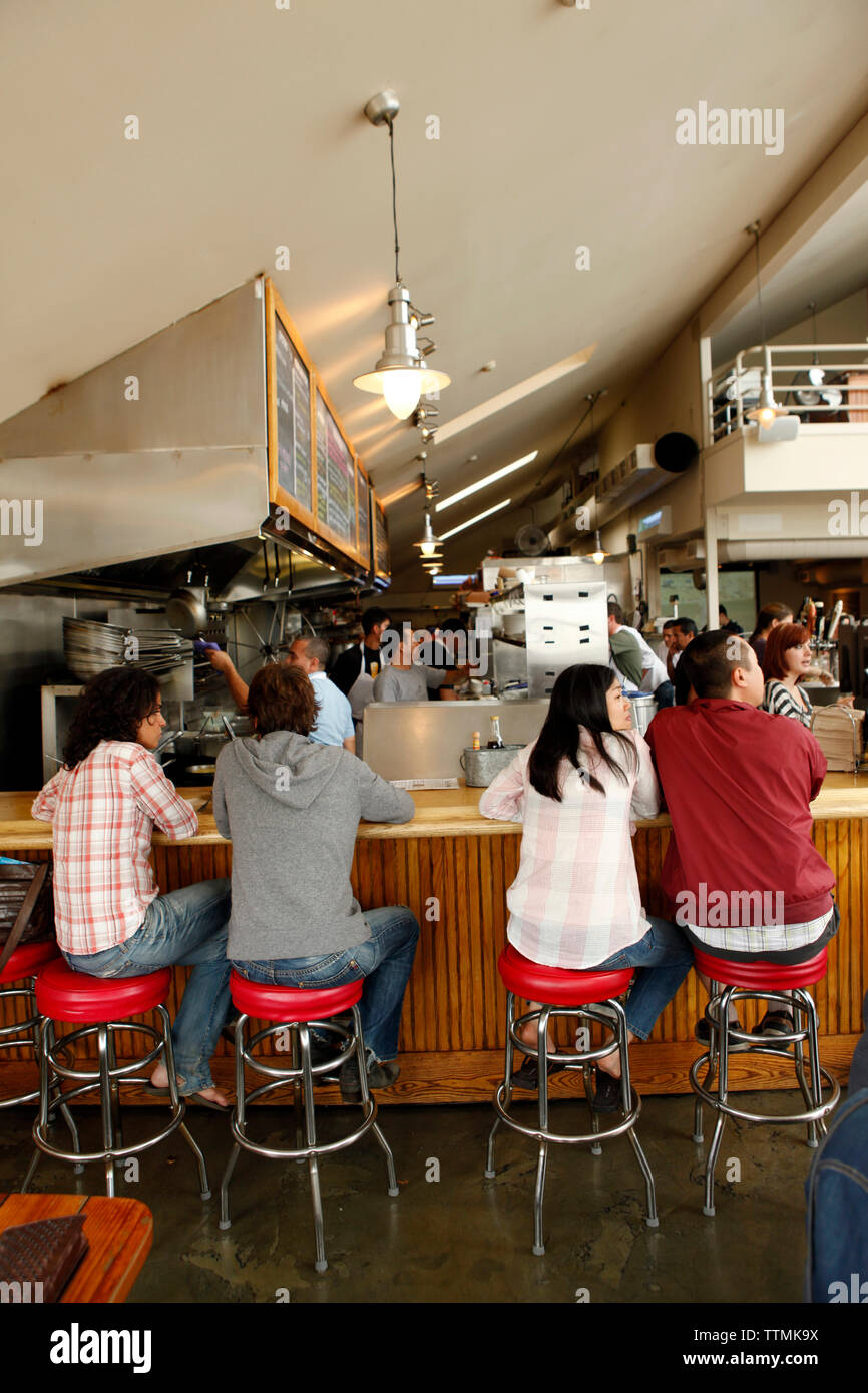 USA, California, Sausalito, guests sit on bar stools and eat lunch