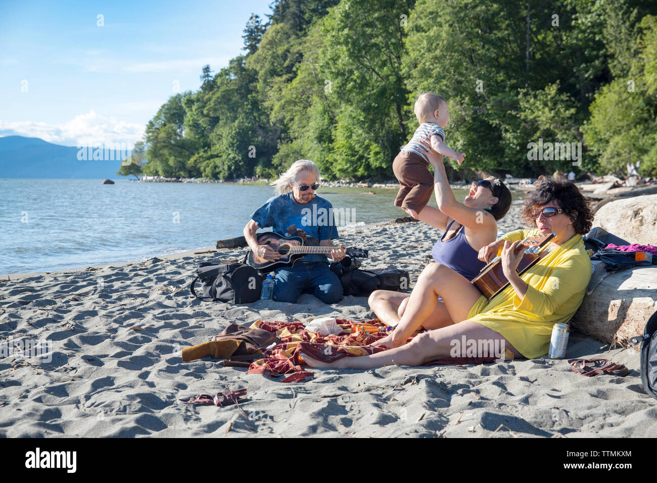 CANADA, Vancouver, British Columbia, friends play music, sing and hang out  at Wreck Beach Stock Photo - Alamy