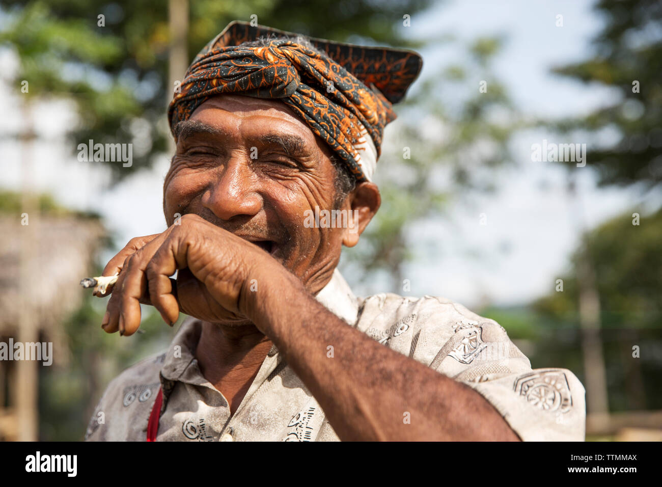 INDONESIA, Flores, an elder man Rufus Goa smokes and has a laugh in Kampung Tutubhada village in Rendu Stock Photo