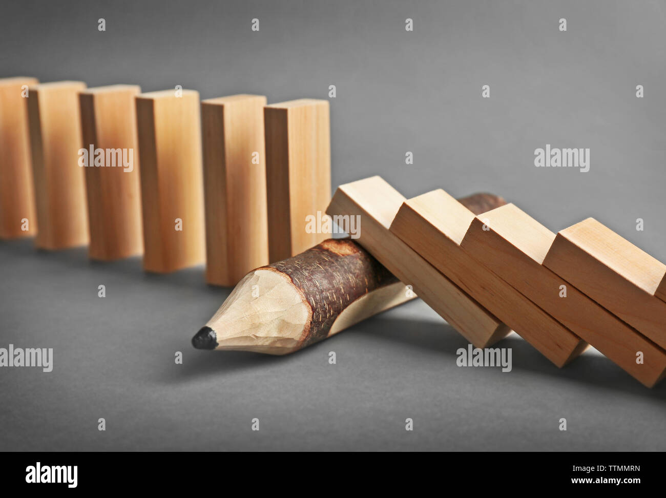 Wooden pencil blocked row of falling dominoes on grey background Stock ...