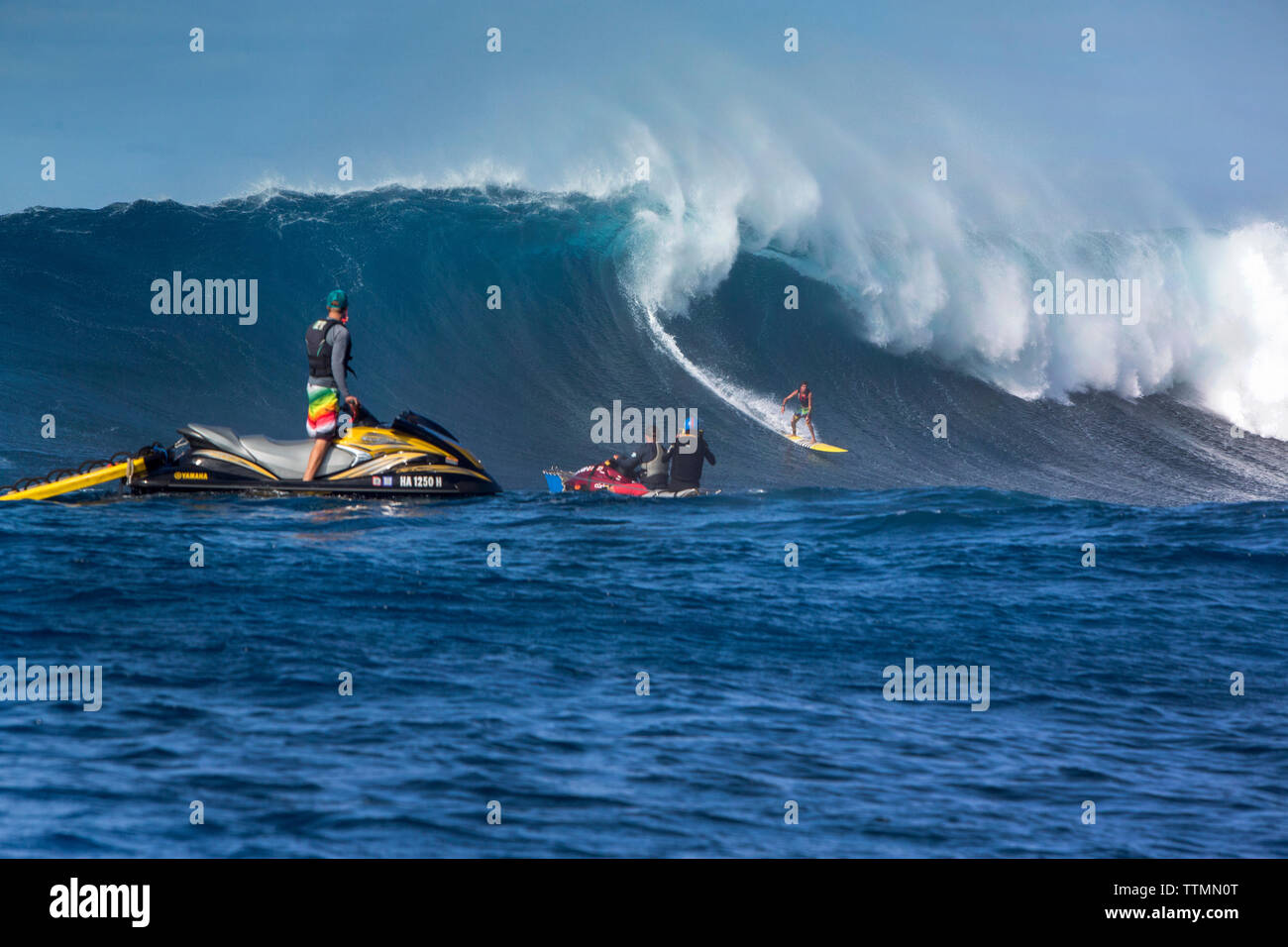 USA, HAWAII, Maui, Jaws, big wave surfers taking off on a wave at Peahi