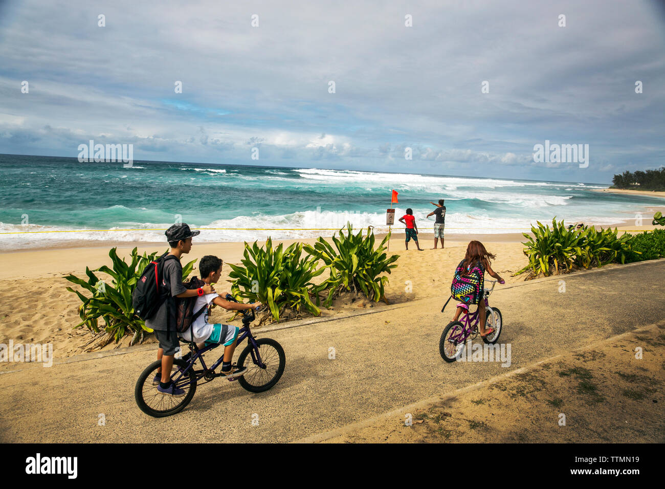 USA, HAWAII, Oahu, Northshore, children riding their bike on the path