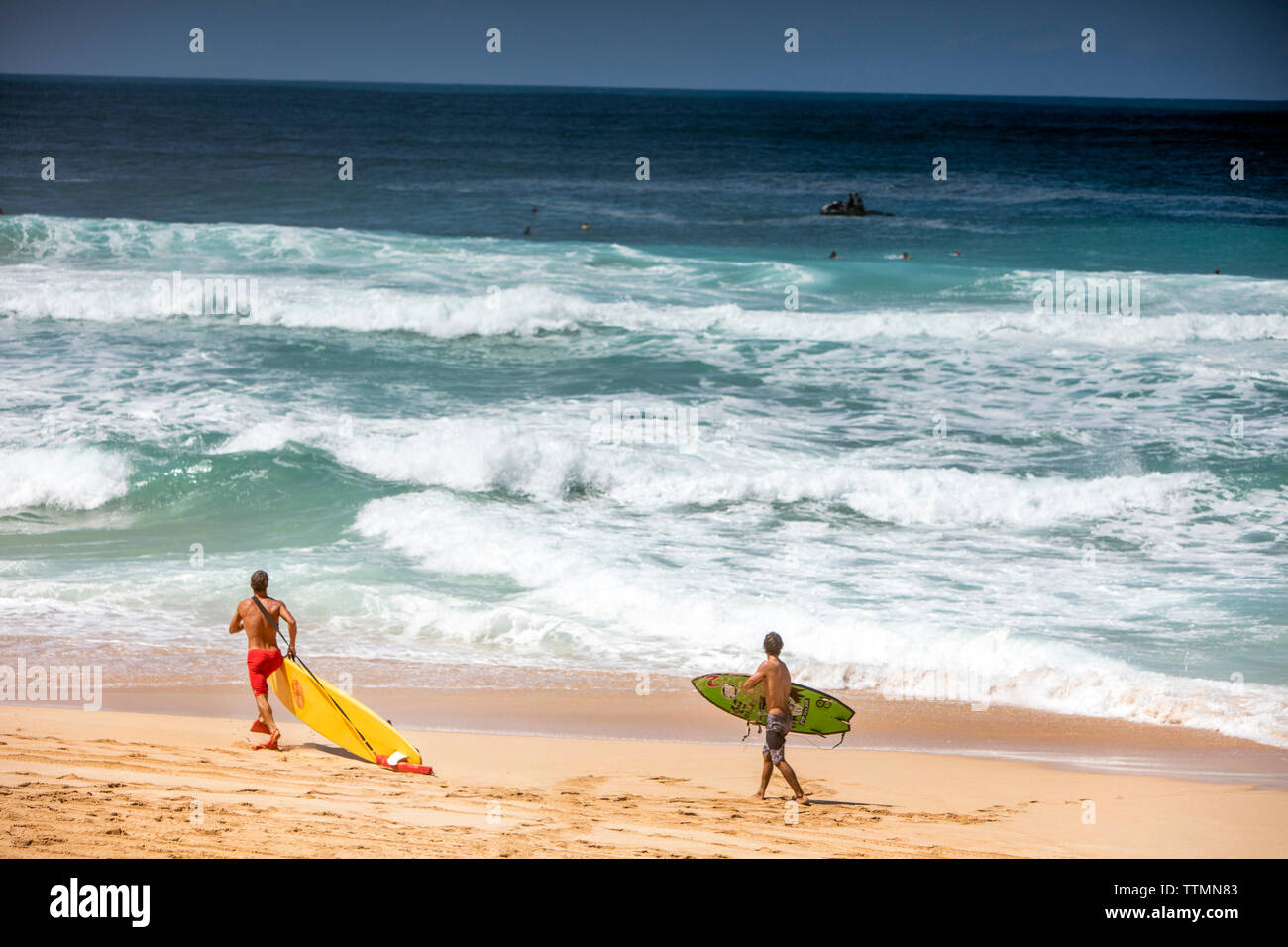 HAWAII, Oahu, North Shore, lifegaurd heading into the water at Pipeline