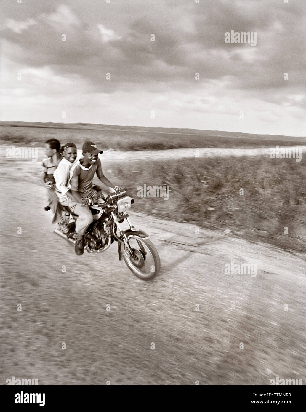 DOMINICAN REPUBLIC, three friends enjoying a motorcycle ride on a rural road near Casa de Campo (B&W) Stock Photo