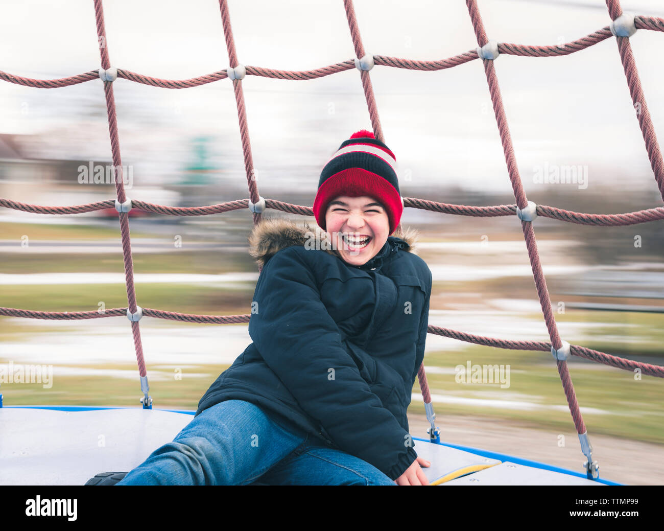 Happy boy enjoying in merry-go-round at playground Stock Photo