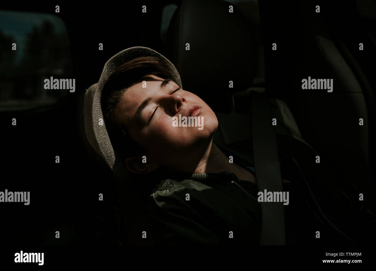 Close-up of boy with eyes closed sitting in car Stock Photo