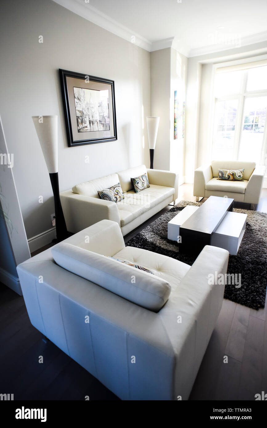 Living room with white modern furnishings in a bright sunny room. Stock Photo