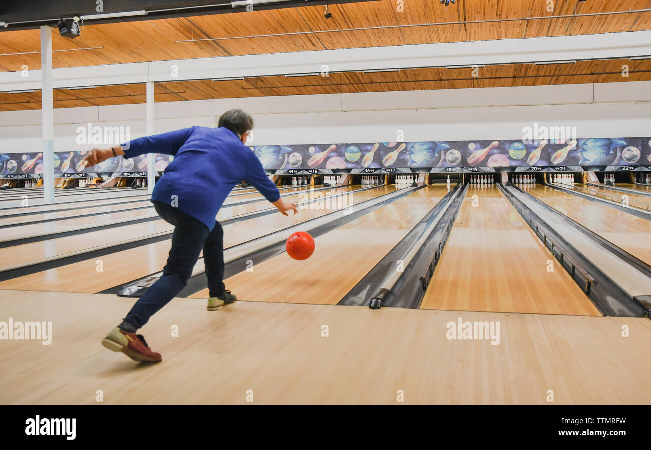 Older woman throwing bowling ball down a bowling lane Stock Photo - Alamy