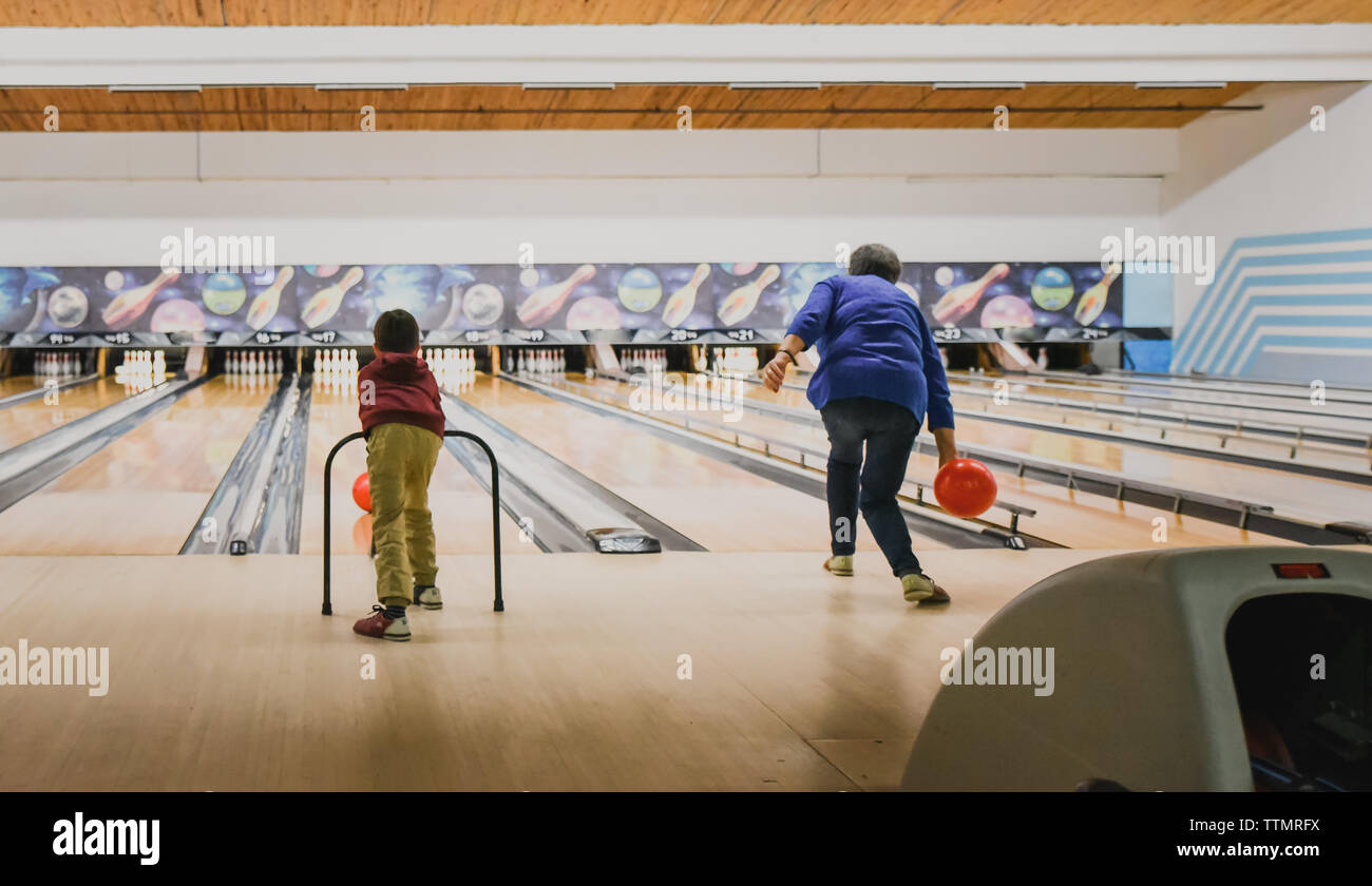 Older woman and young child bowling together at bowling alley. Stock Photo