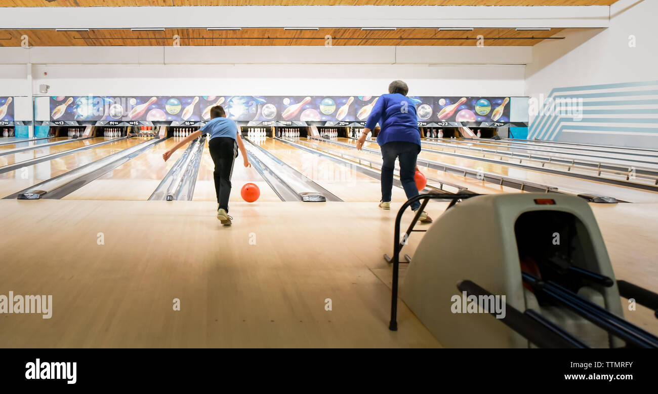 Older woman and child bowling together at a bowling alley. Stock Photo