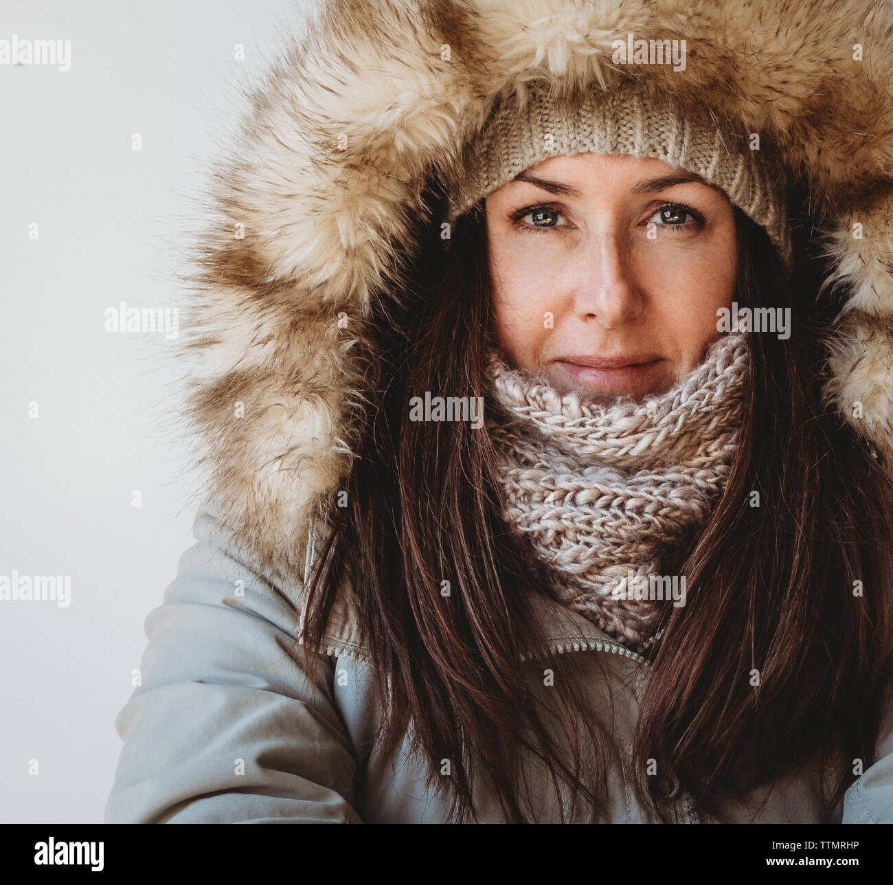 Close up of woman wearing winter clothing against white background. Stock Photo