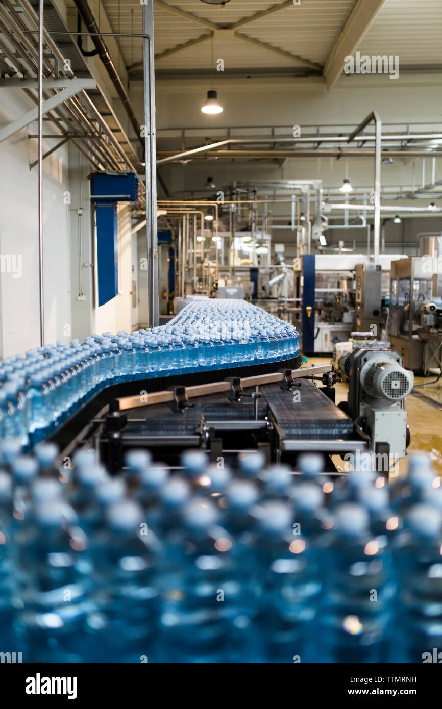 Water bottles on conveyor belt at factory Stock Photo