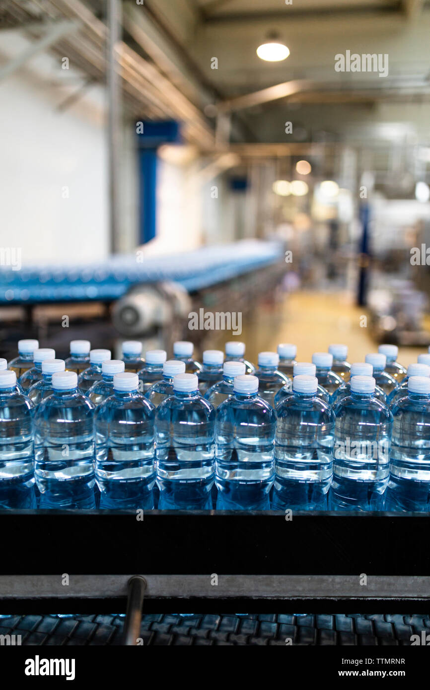 Bottles on conveyor belt at factory Stock Photo