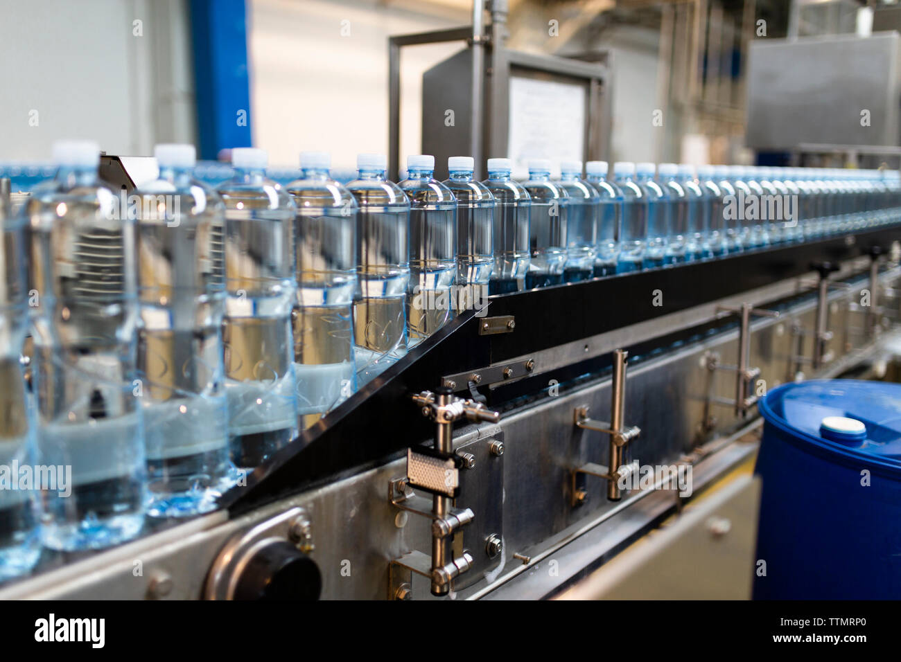 Close-up of water bottles in row on food processing plant at factory Stock Photo
