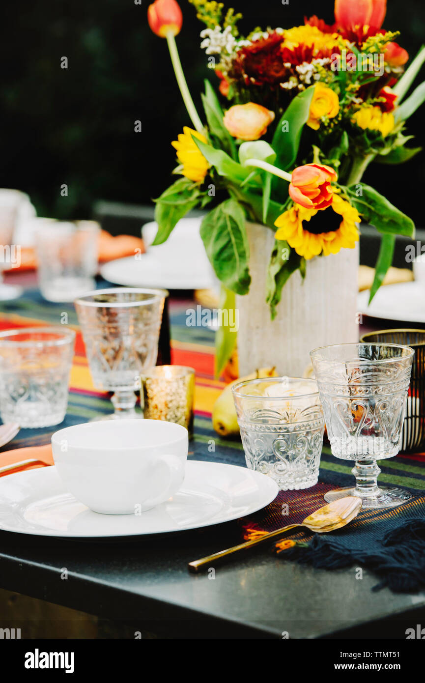 Flower vase with crockery arranged on table in backyard Stock Photo