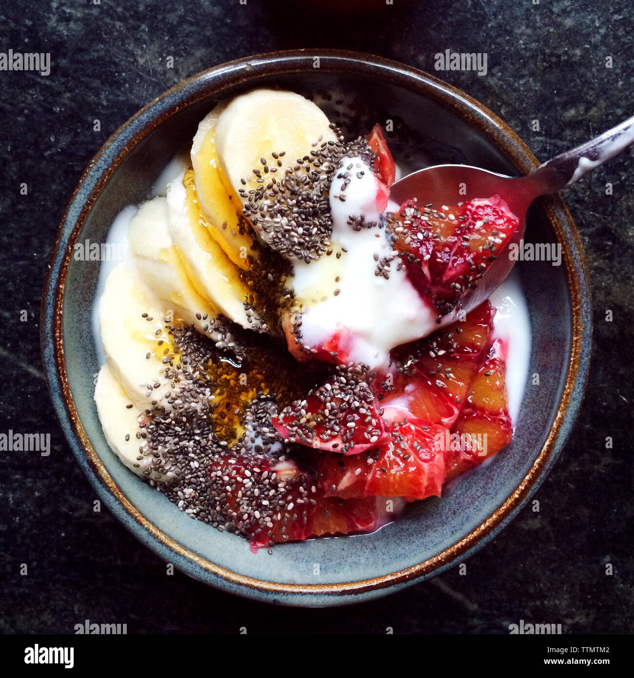 Bowl of fruits with honey, yogurt and seeds Stock Photo