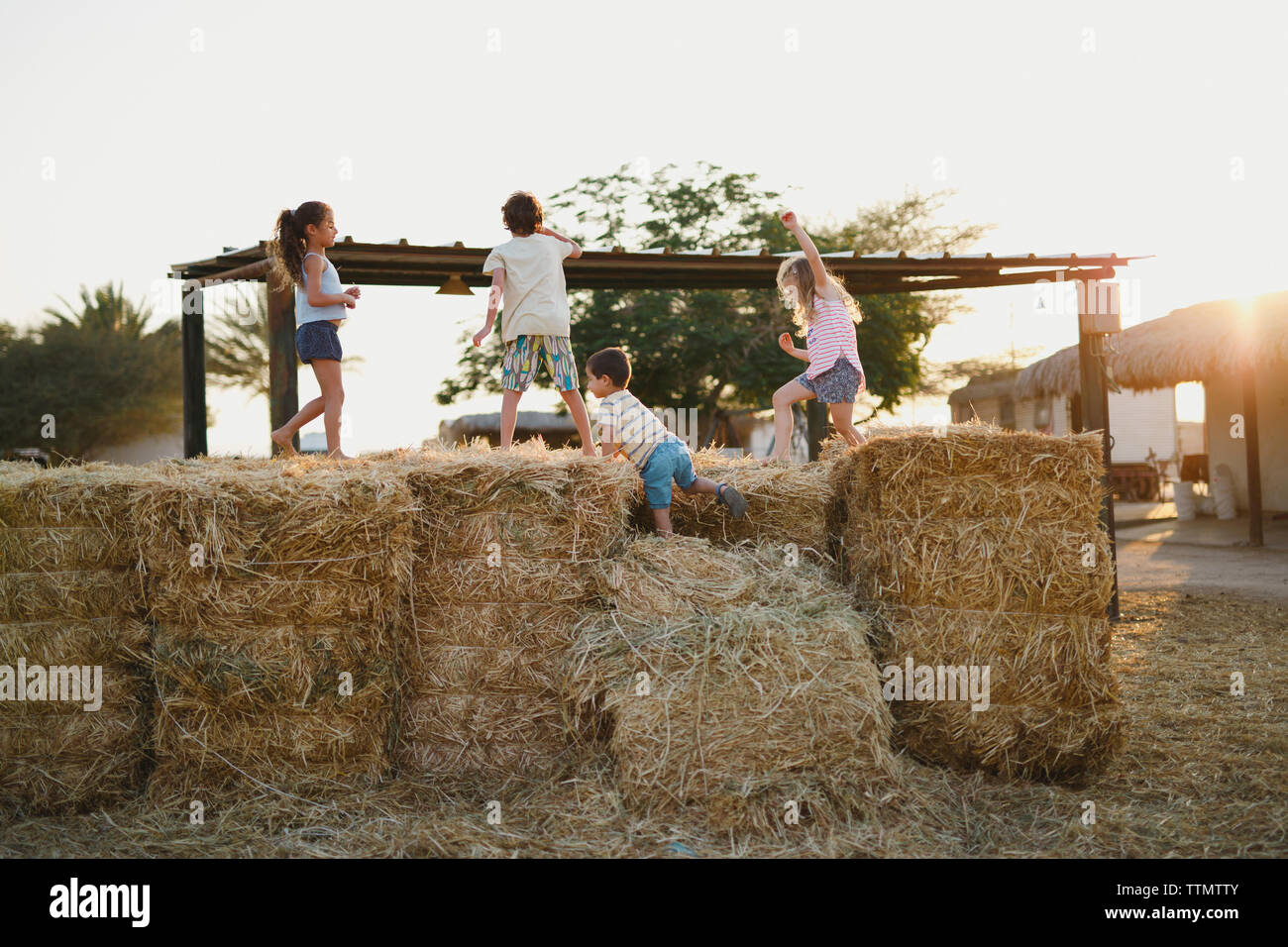 Kids standing and playing on hay bales Stock Photo