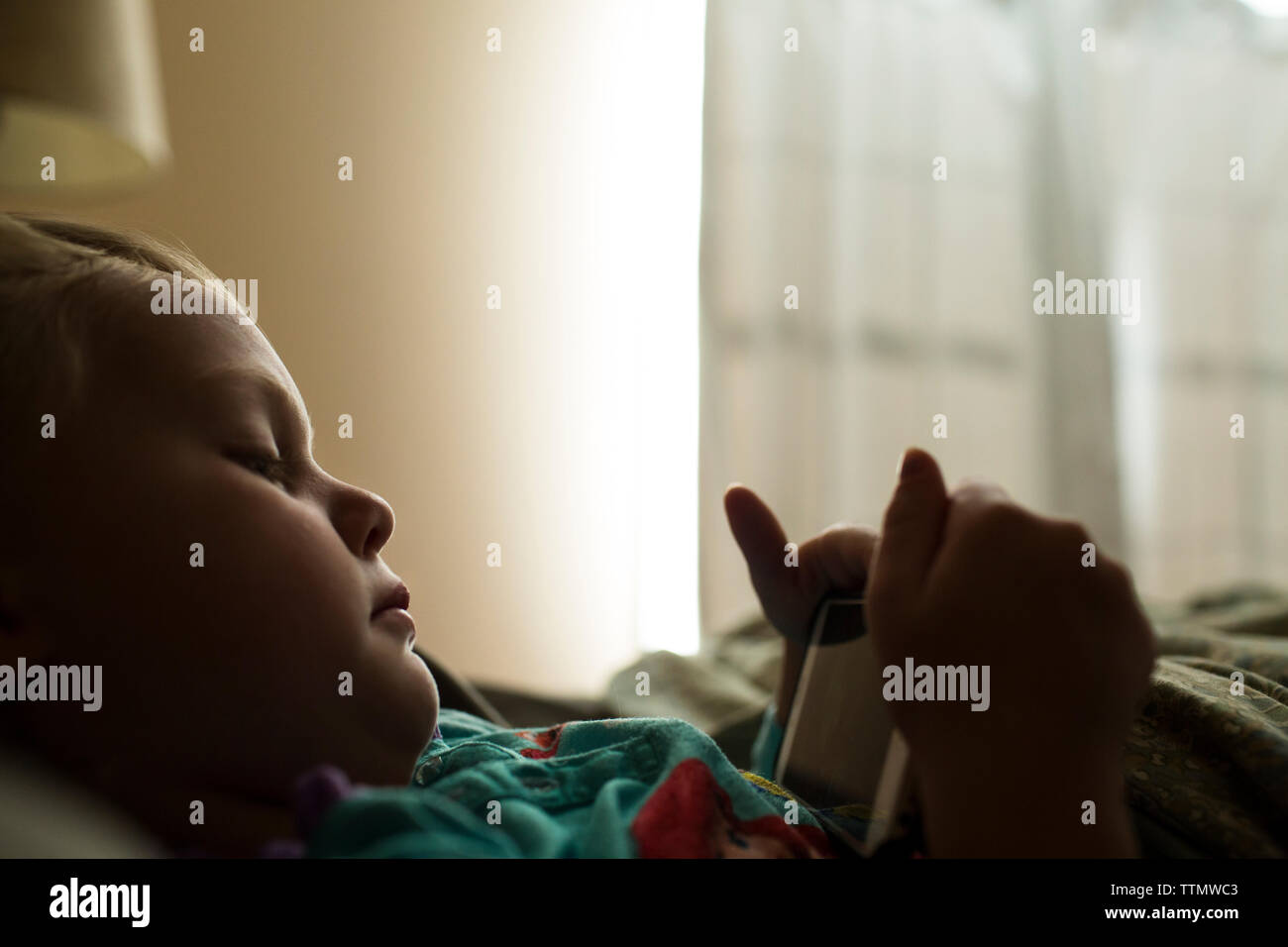 Girl lying on bed holding hi-res stock photography and images - Alamy