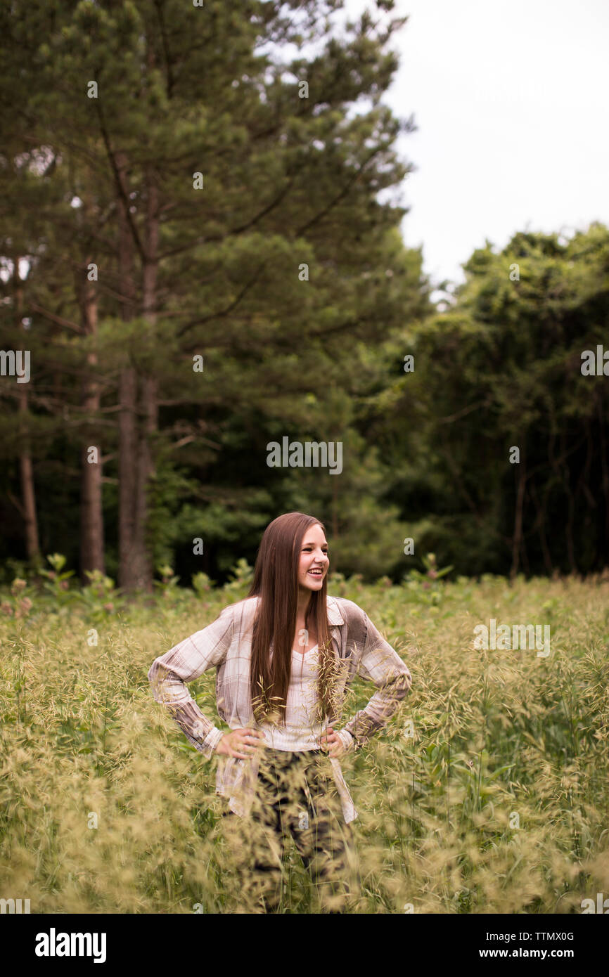 Laughing Teenage Girls Stands in Green Field in Front of Woods Stock Photo