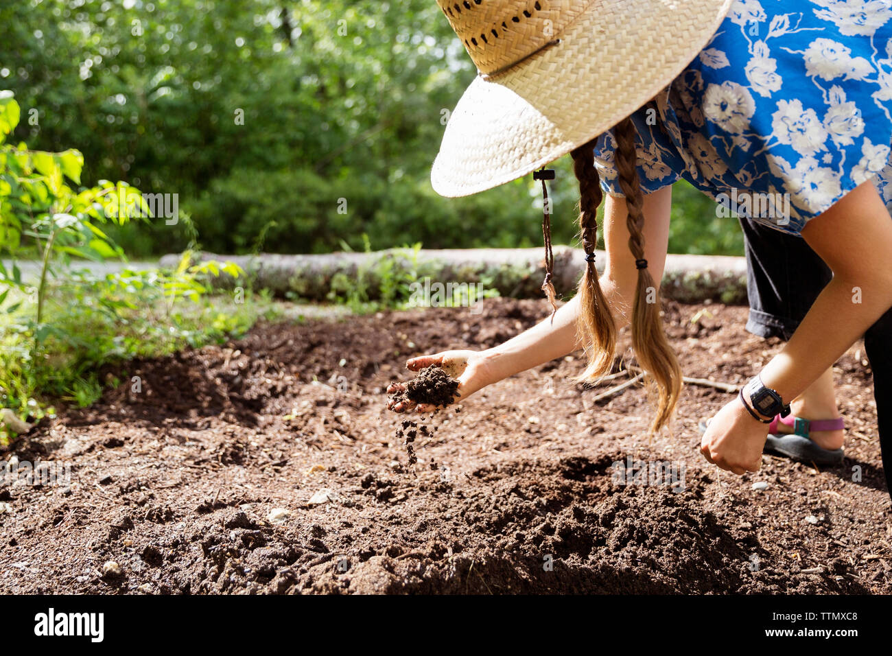 Woman bending while analyzing soil quality on field Stock Photo