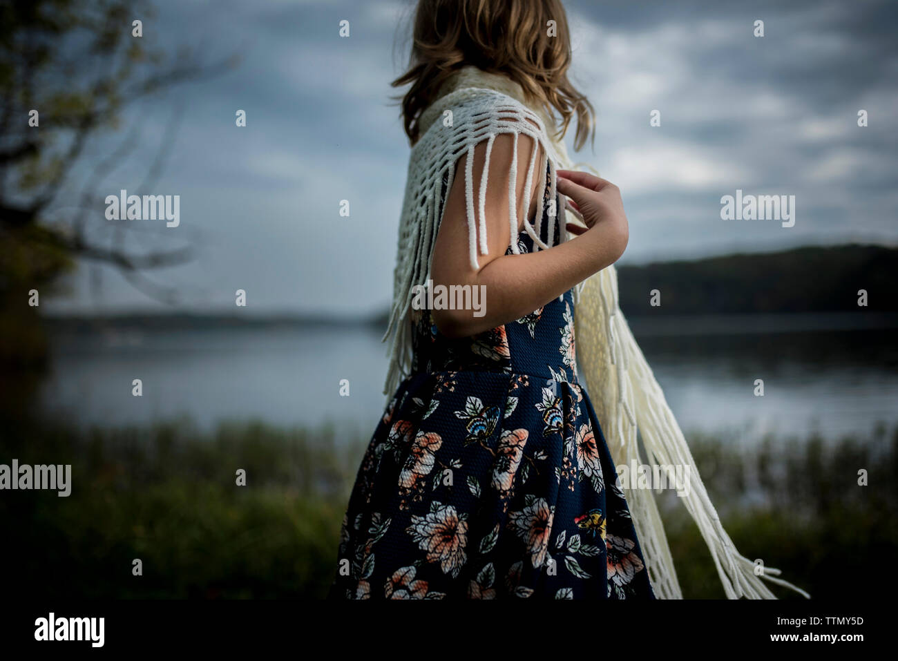 Side view of girl standing on field by river against sky Stock Photo ...
