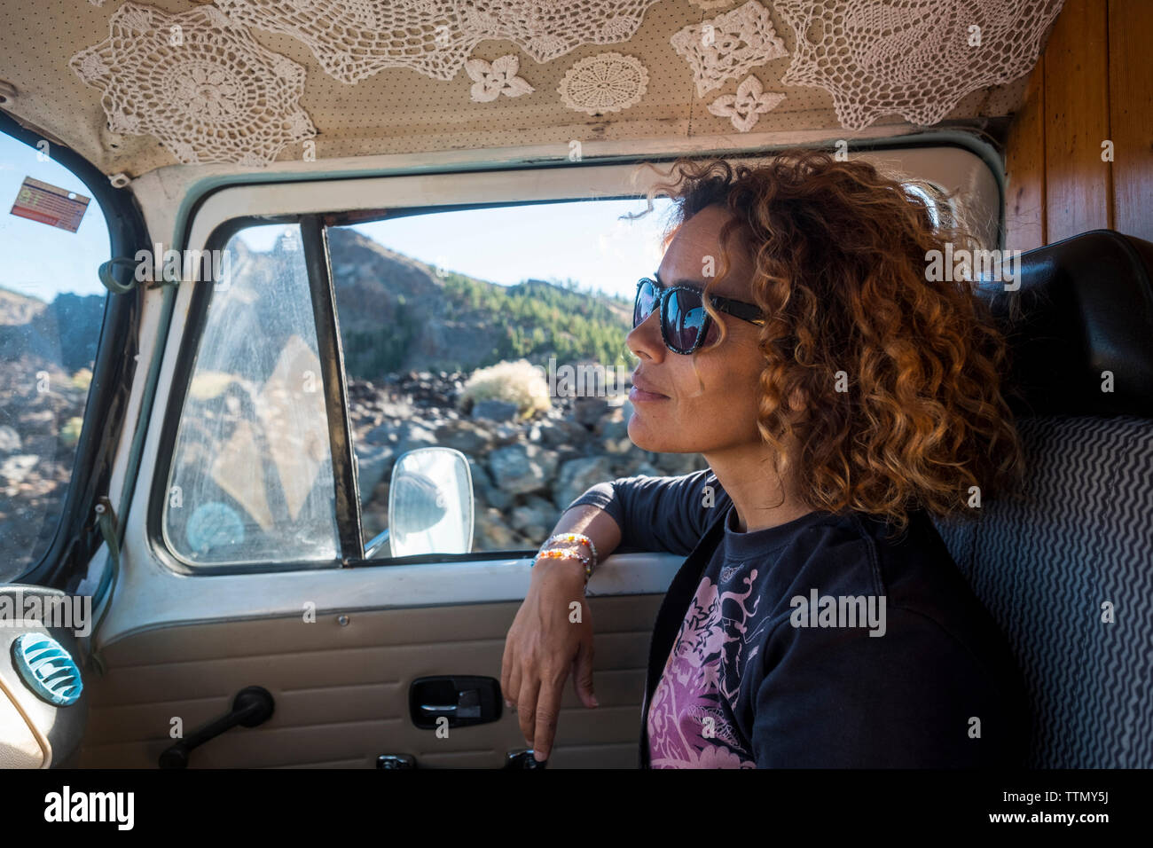 Thoughtful woman looking away while wearing sunglasses in camper trailer Stock Photo