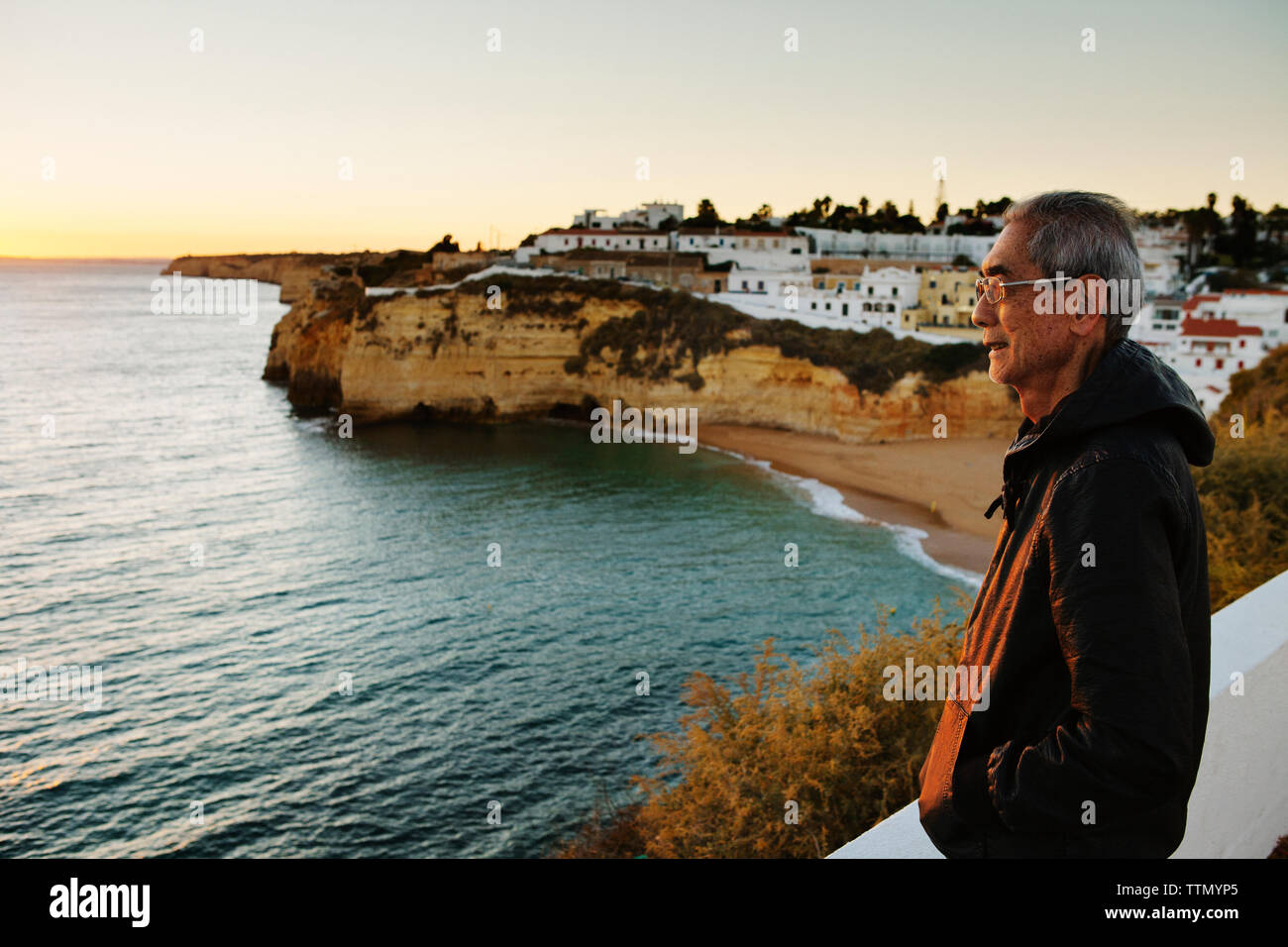 Side view of thoughtful senior man looking at sea by city Stock Photo