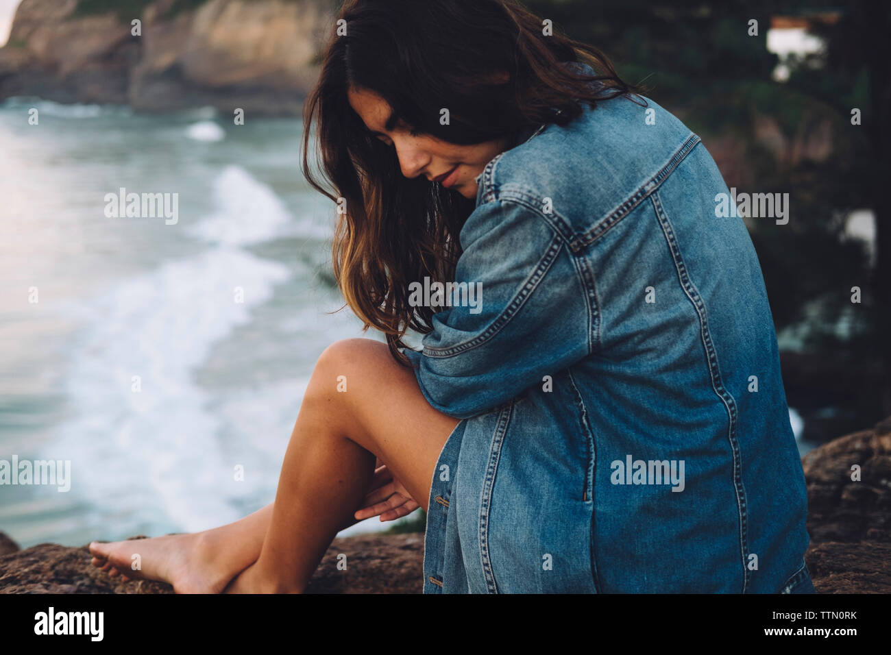 Woman sitting rock sunset hi-res stock photography and images - Alamy