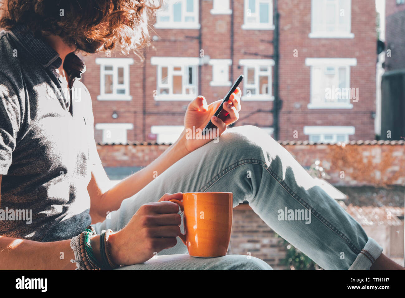 Caucasian using his phone while having a coffee Stock Photo