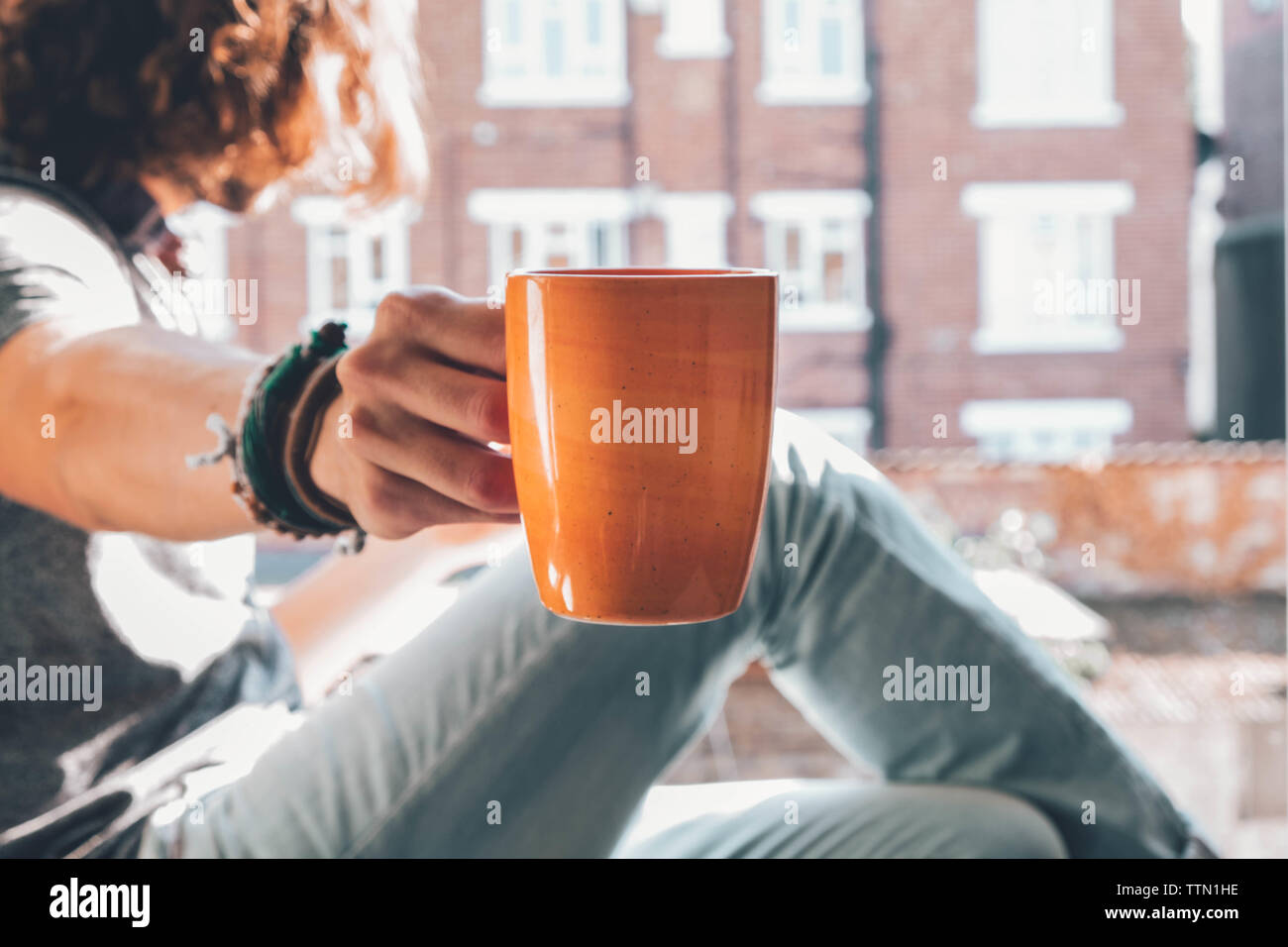 Caucasian offering his coffee mug while looking other side Stock Photo