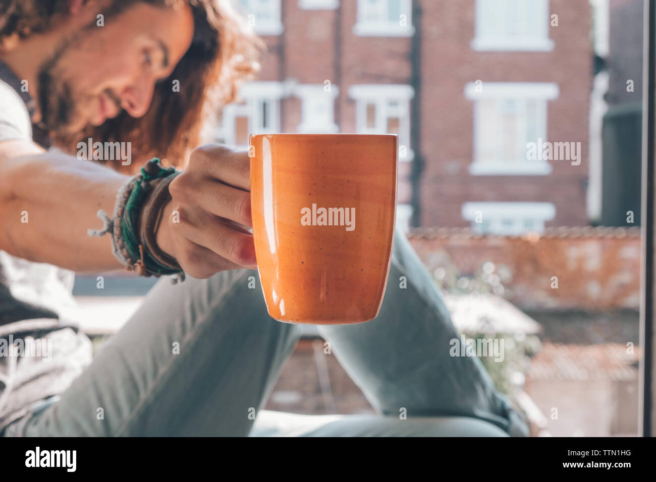 Caucasian offering his coffee mug while looking other side Stock Photo