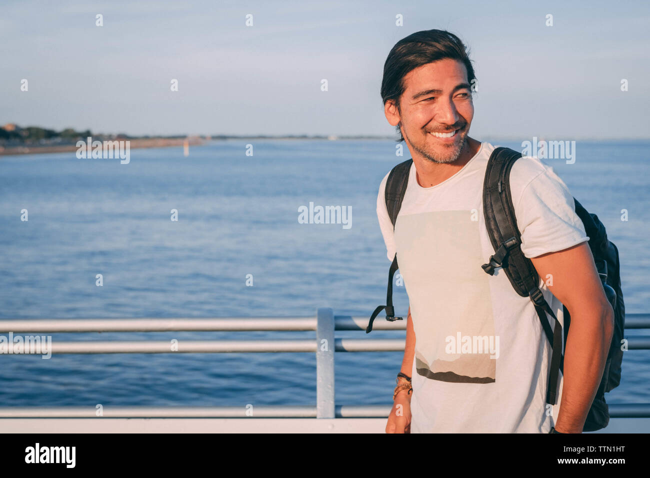 Brazilian laughing on a pier at the sunset with sea views Stock Photo