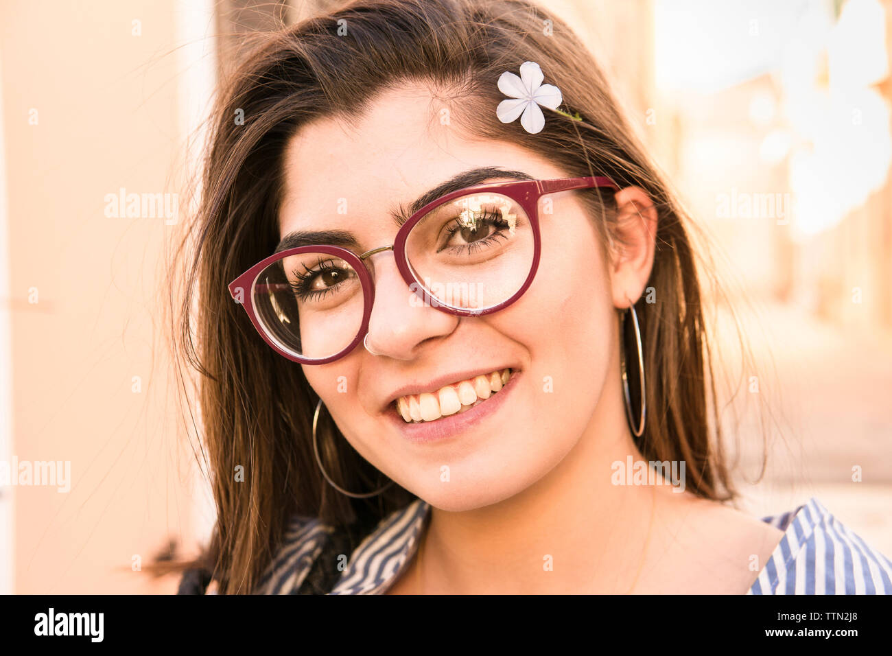 Close-up portrait of smiling teenage girl wearing flower Stock Photo