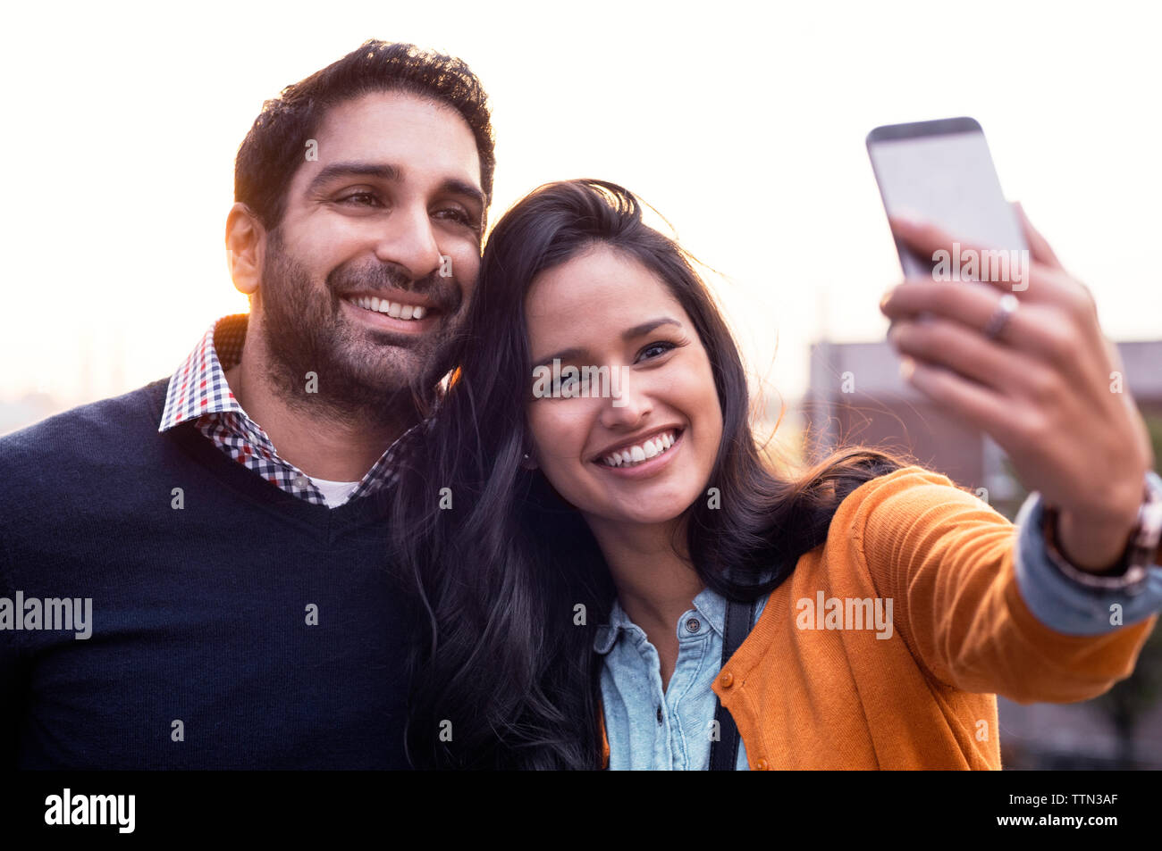 Couple taking selfies at sunset Stock Photo