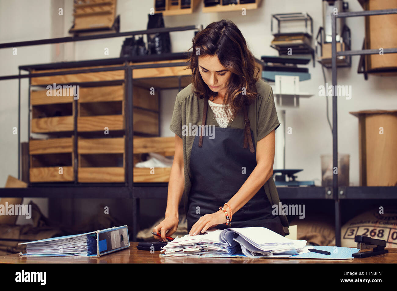Mature female owner doing paperwork at coffee shop Stock Photo