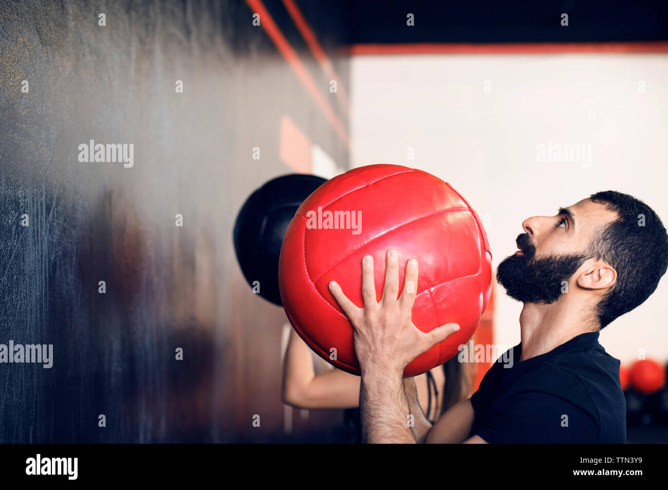 Side view of man throwing medicine ball at gym Stock Photo Alamy