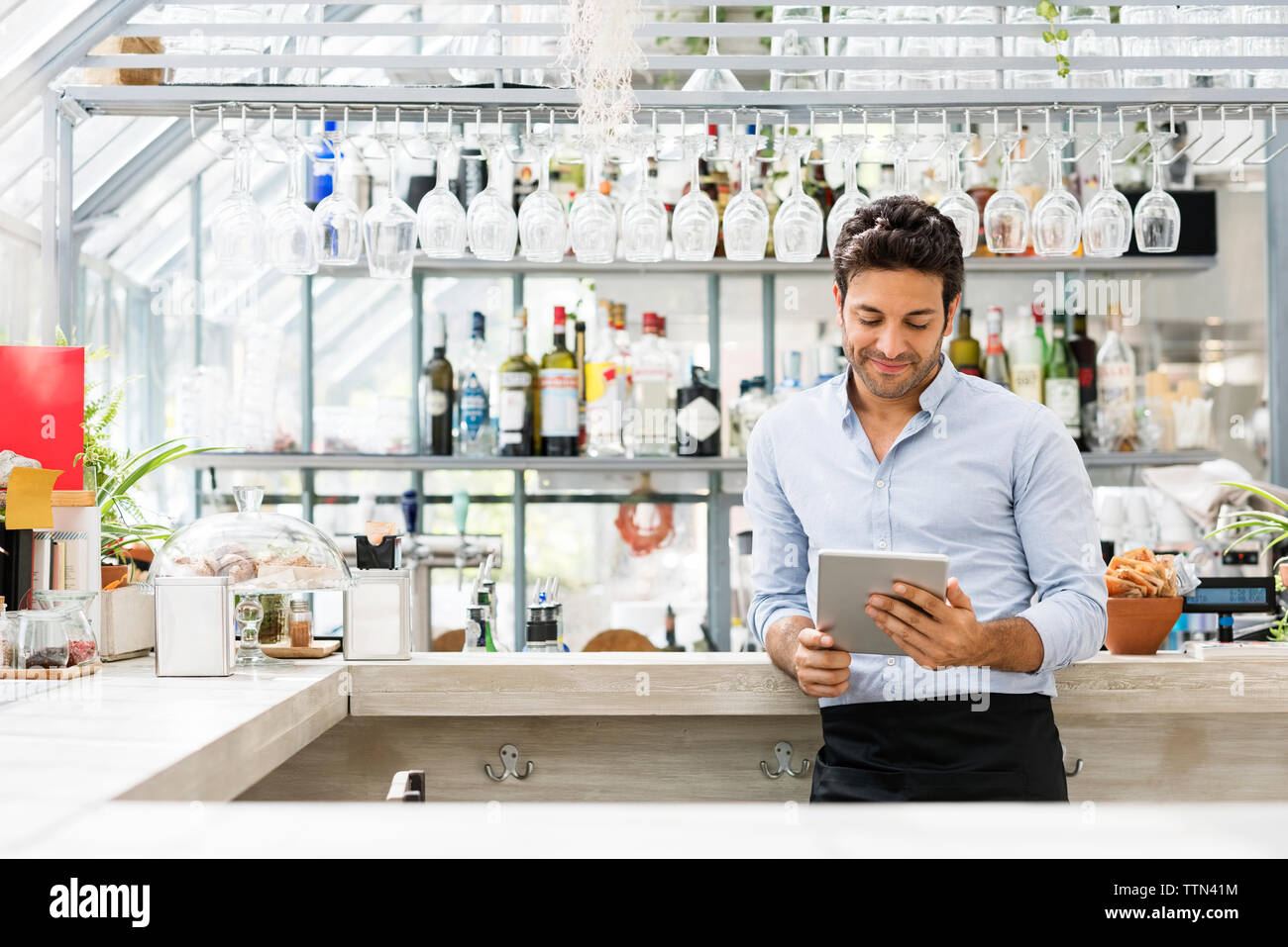 Bartender using tablet computer at counter in restaurant Stock Photo