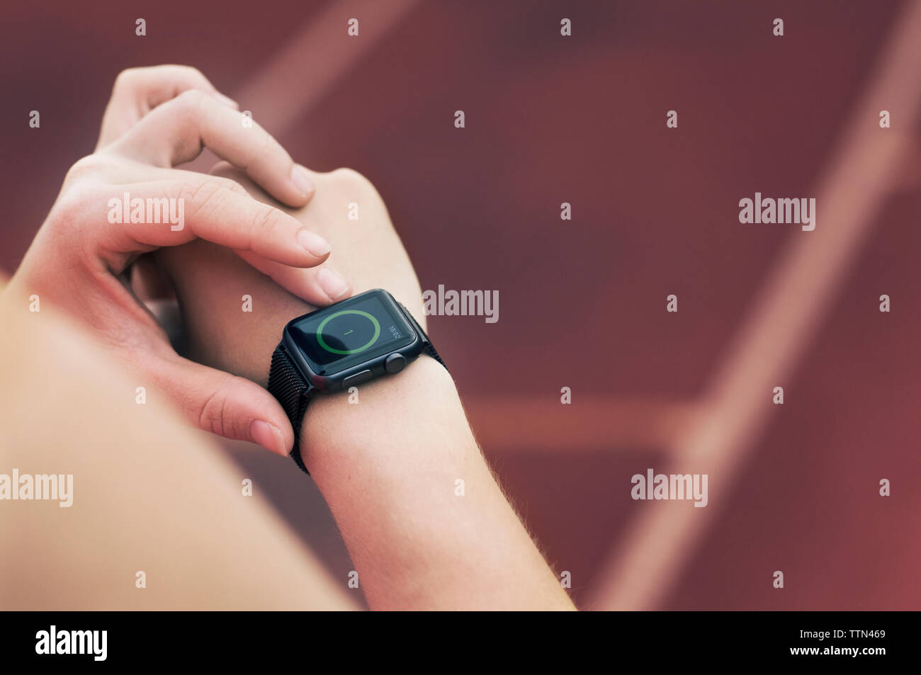 High angle view of athlete setting smart watch Stock Photo