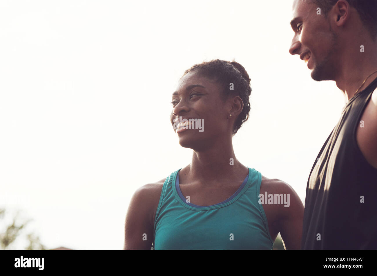 Low angle view of athletes talking while standing against sky during sunset Stock Photo