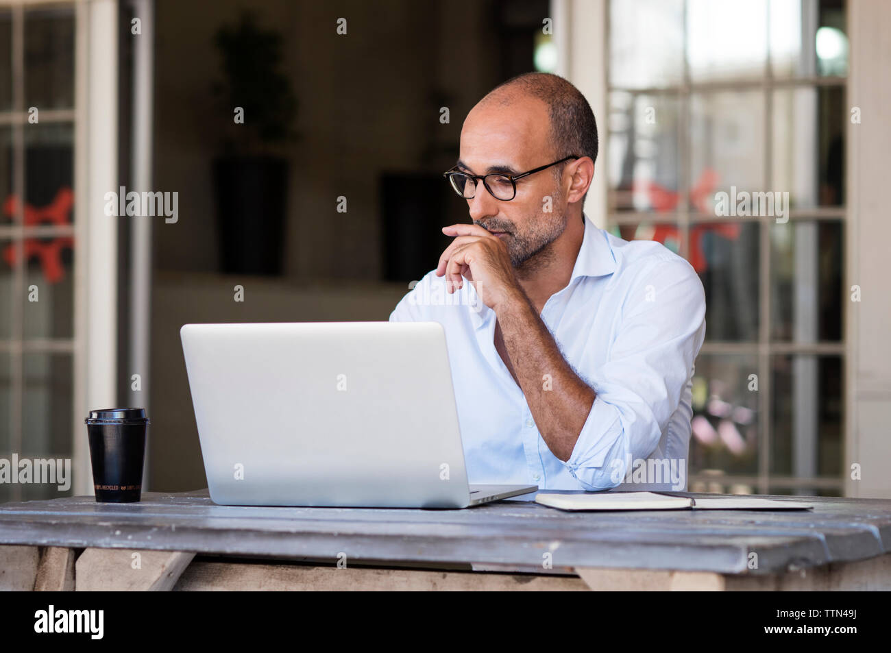 businessman using laptop computer while sitting at table in office Stock Photo