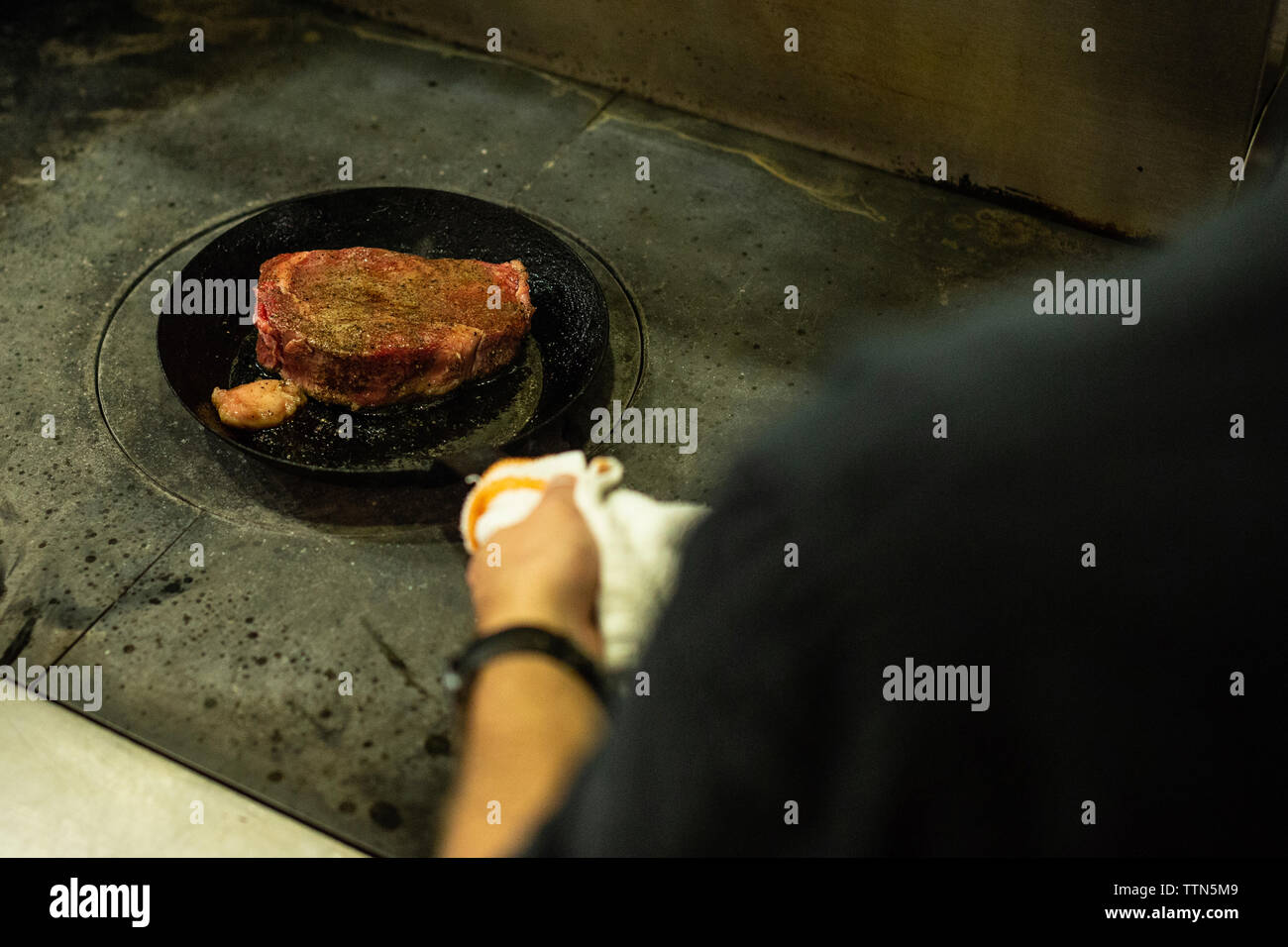 Cropped hand of man preparing food on stove Stock Photo