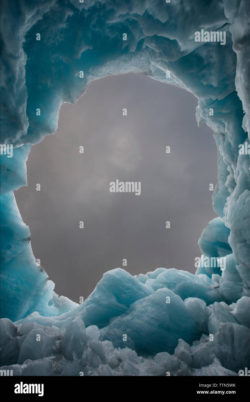 Cloudy sky seen through ice formation Stock Photo Alamy
