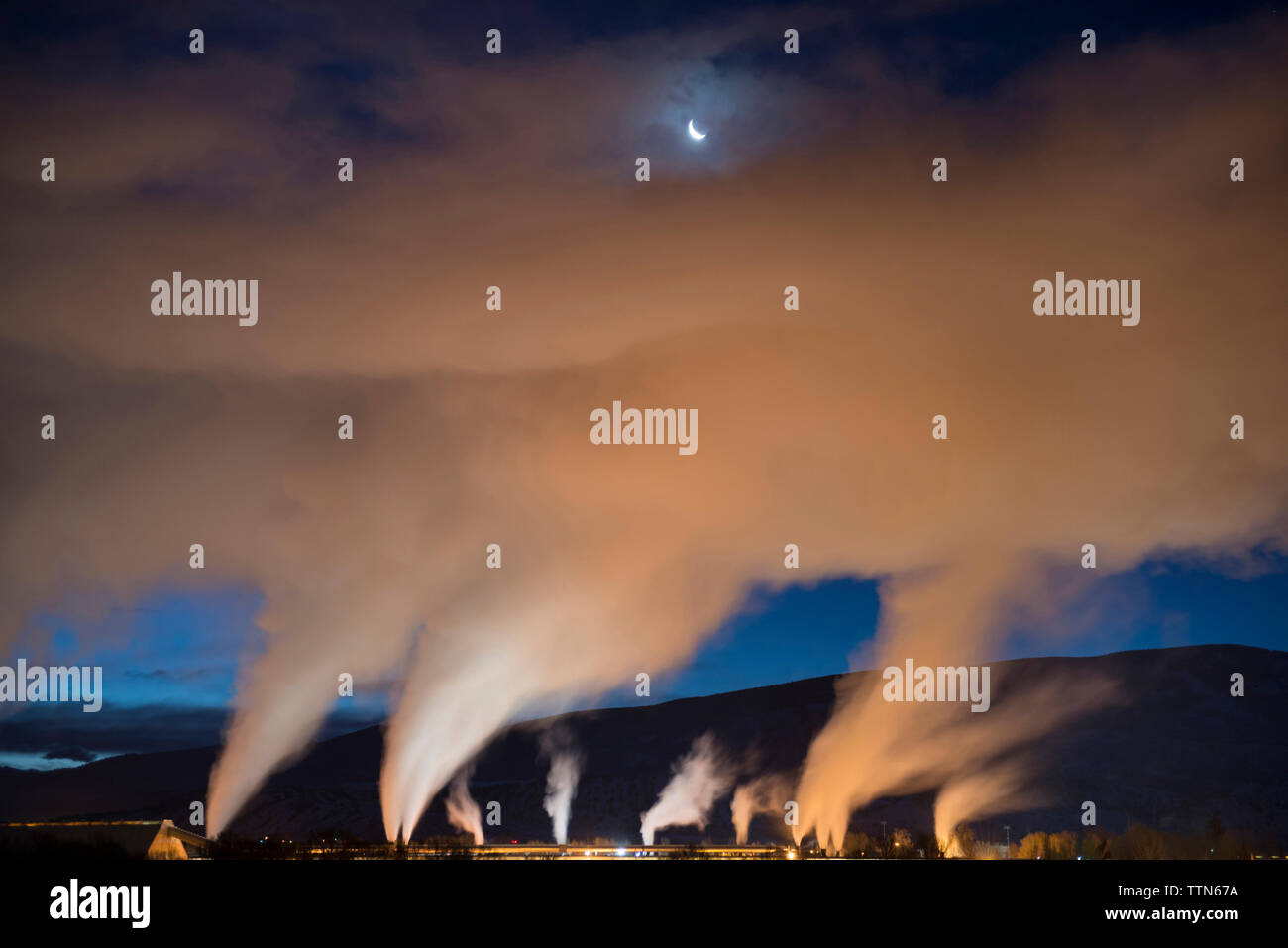 Low angle view of smoke emitting from industry at dusk Stock Photo