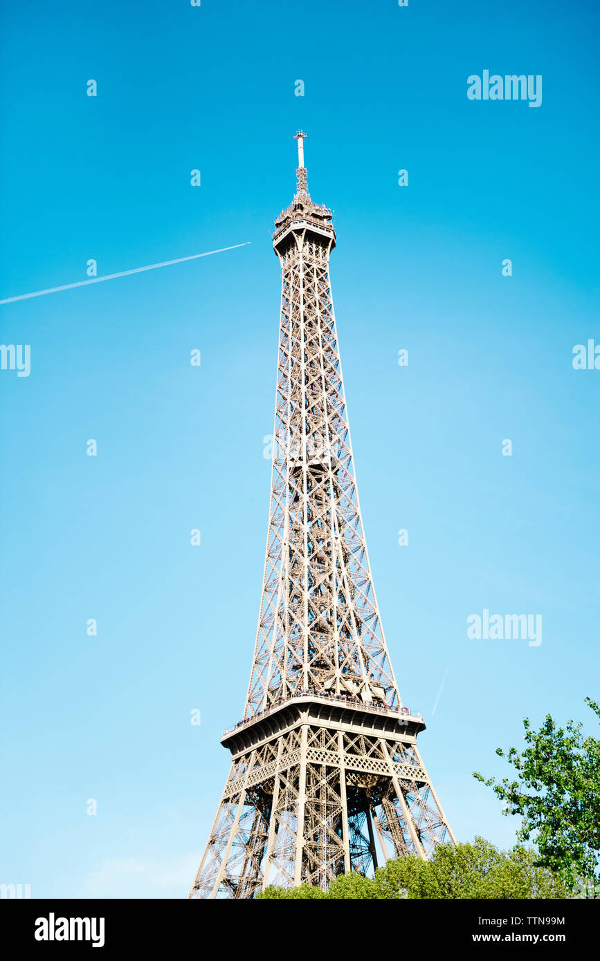 Low angle view of Eiffel Tower against blue sky on sunny day Stock Photo