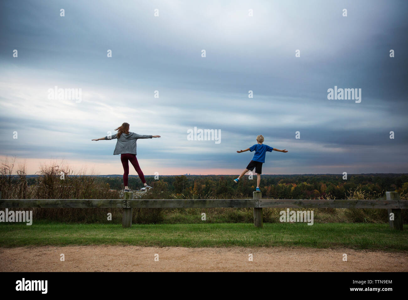 Boy and girl on fence boy and girl on fence hires stock photography