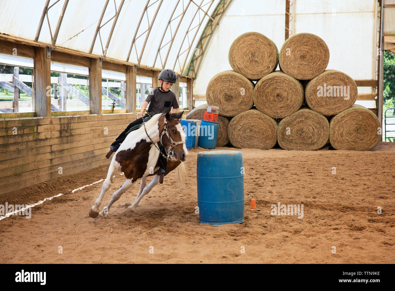 Boy riding horse in ranch Stock Photo