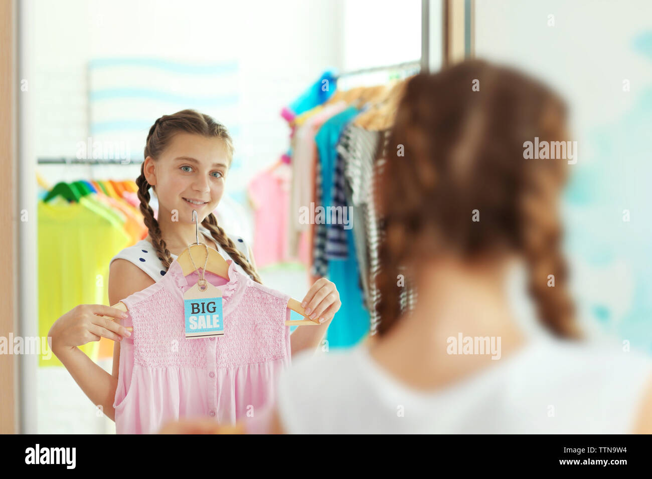 Pretty girl choosing clothes near mirror Stock Photo Alamy