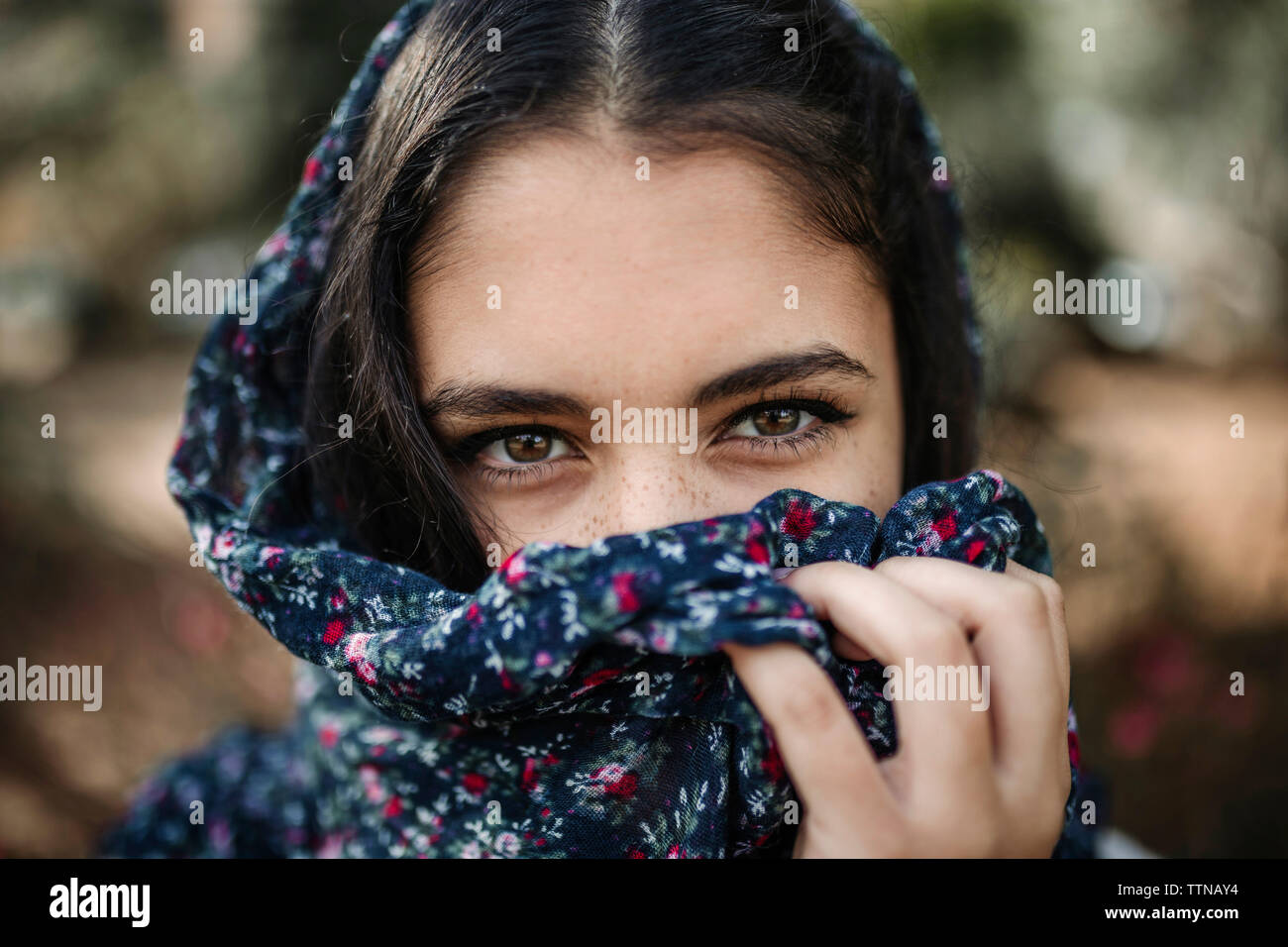 Close-up portrait of teenage girl with obscured face standing outdoors Stock Photo