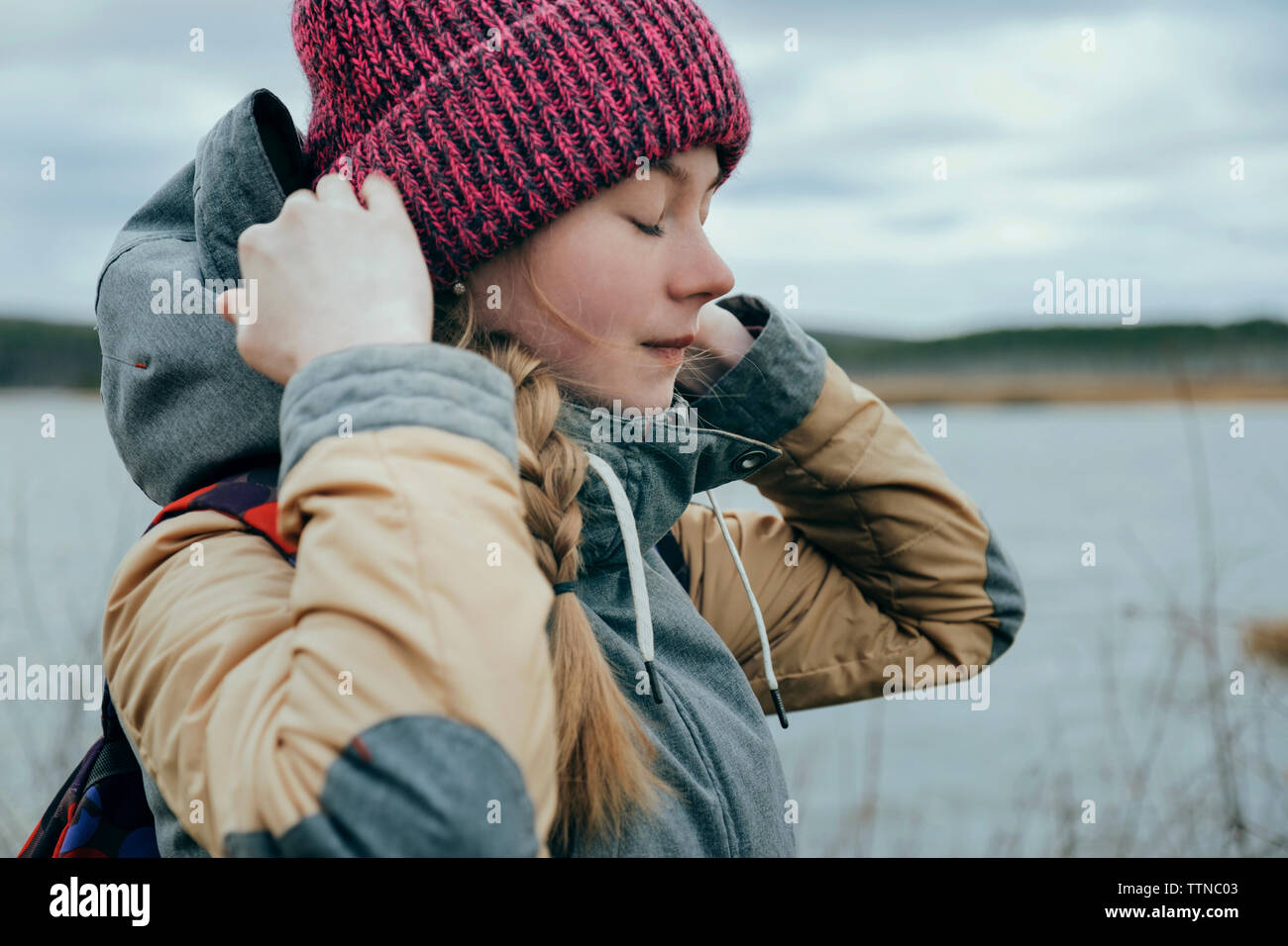 Beautiful girl by the river wearing knitted hat Stock Photo - Alamy